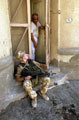 A private from the Cheshire Regiment, sits in a doorway, Basra, Iraq, June 2004