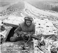 A member of the 1st Battalion, The Rifle Brigade, leaving a dug-out,  28 December 1944