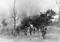 Indian infantry advance through a burning village, Burma, 1945
