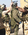 An EOD operator is helped into a protective bomb suit, Iraq, 2006 (c)