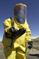 An officer from 33 Engineer Regiment (Explosive Ordnance Disposal) in protective clothing with a chemical agent monitor, Afghanistan, 2002