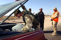 A weapons search at a vehicle checkpoint, Al Zubayr Port, Iraq, 2003.