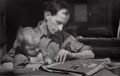 Frank Tomlinson looking through an album with his son, 1945 (c)