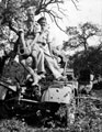 Two members of 3rd County of London Yeomanry sit astride a knocked out German 88mm gun in Italy, 1943