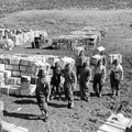 A 'compo ration' dump and men carrying supplies to it, March 1943