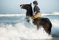 A member of King's Troop Royal Horse Artillery training in the sea at Watergate Bay Beach, Cornwall, 2015