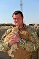 A member of  7th Parachute Regiment Royal Horse Artillery with a cat, near Gereshk in Helmand Province, Afghanistan, 2011