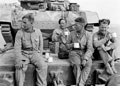 Members of 3rd County of Yeomanry, 7th Armoured Division, seated on a railway flat car, 1942