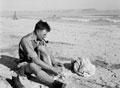Douglas H Jackson, 3rd County of London Yeomanry (Sharpshooters),dries his feet on a beach in North Africa, 1942