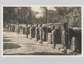 Soldiers of the King's African Rifles line up outside the traditional huts they had built, Assam, 1945 (c)