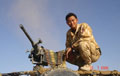 A member of the Royal Gurkha Rifles next to a L1A1 Heavy Machine Gun, Helmand, Afghanistan, July 2006.