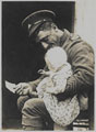 A British soldier minding the baby outside his billet in Adinkerke, 6 August 1917