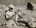 Colonel Guy Hamilton Russell filling in his game book while on a hunting expedition, 1930 (c)