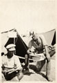 Two British soldiers reading newspapers outside their tent, 1917 (c)