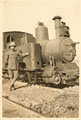 A British soldier leaning against a railway engine on the desert railway, 1917 (c)