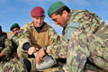 A corporal from the Royal Army Medical Corps trains a soldier of the Afghan National Army to apply a field dressing, near Gereshk, Helmand Province, January 2011.