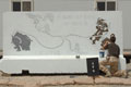 Soldier painting blast wall mural, Contingency Operating Base, Basra Air Station, Iraq, 2009
