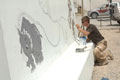 Soldier painting blast wall mural, Contingency Operating Base, Basra Air Station, Iraq, 2009