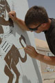 Soldier painting blast wall mural, Contingency Operating Base, Basra Air Station, Iraq, 2009