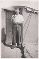 Sergeant George Davies holding a cat outside his tent, 1937 (c)