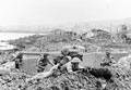 Infantry take up positions besides a knocked out coastal gun, Pantellaria, 11 June 1943