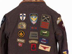 Child's dressing gown with cloth badges sewn on it, 1943 (c)