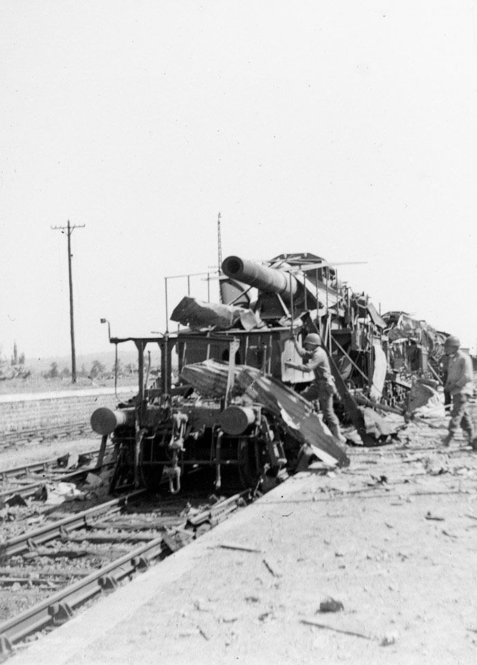 American soldiers examining destroyed German guns at Vire railway station in Normandy, 1944