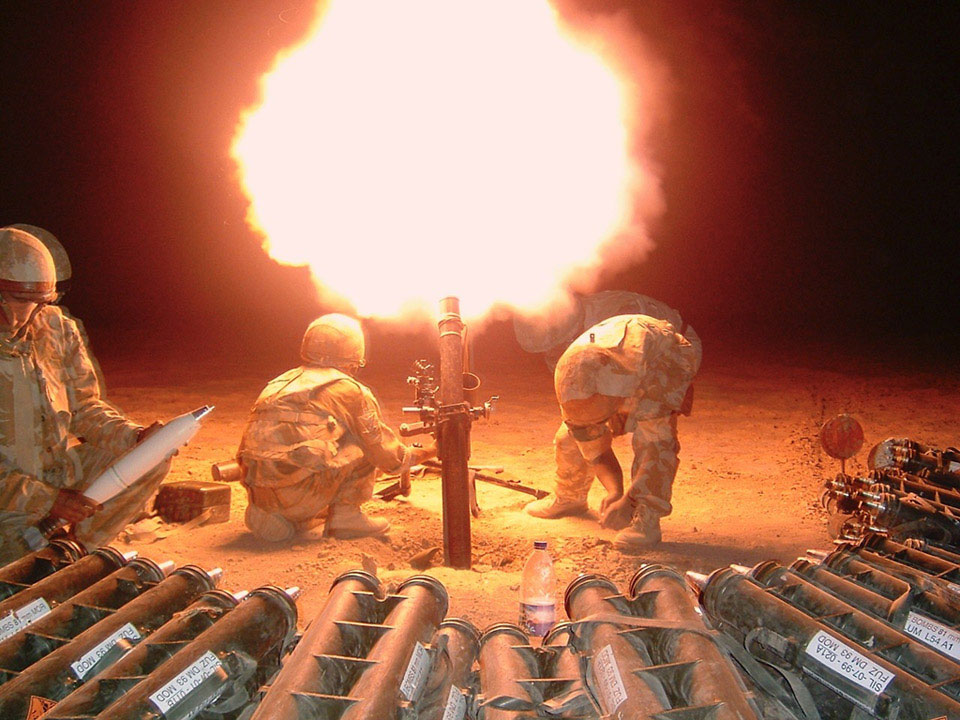 Soldiers of the Royal Irish Regiment fire mortar rounds during a contact at night in Musa Qala, 2006
