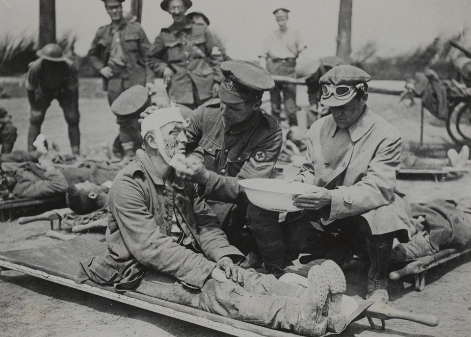 A British medical orderly treats a wounded German soldier, 1916-1918 (c)