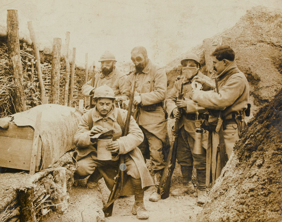 French troops don their gas masks while manning a trench on the Western Front, 1915 (c)