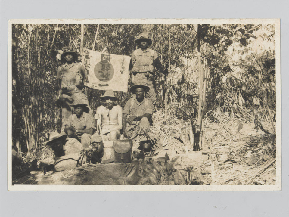 Soldiers with captured Japanese flag at Leik Hill, 1944