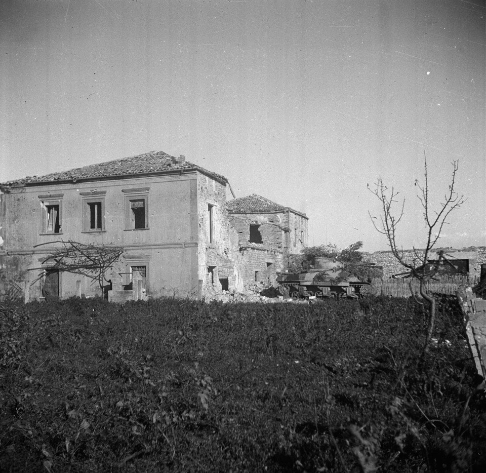 Camouflaged British Sherman tanks parked near farm buildings in Italy ...