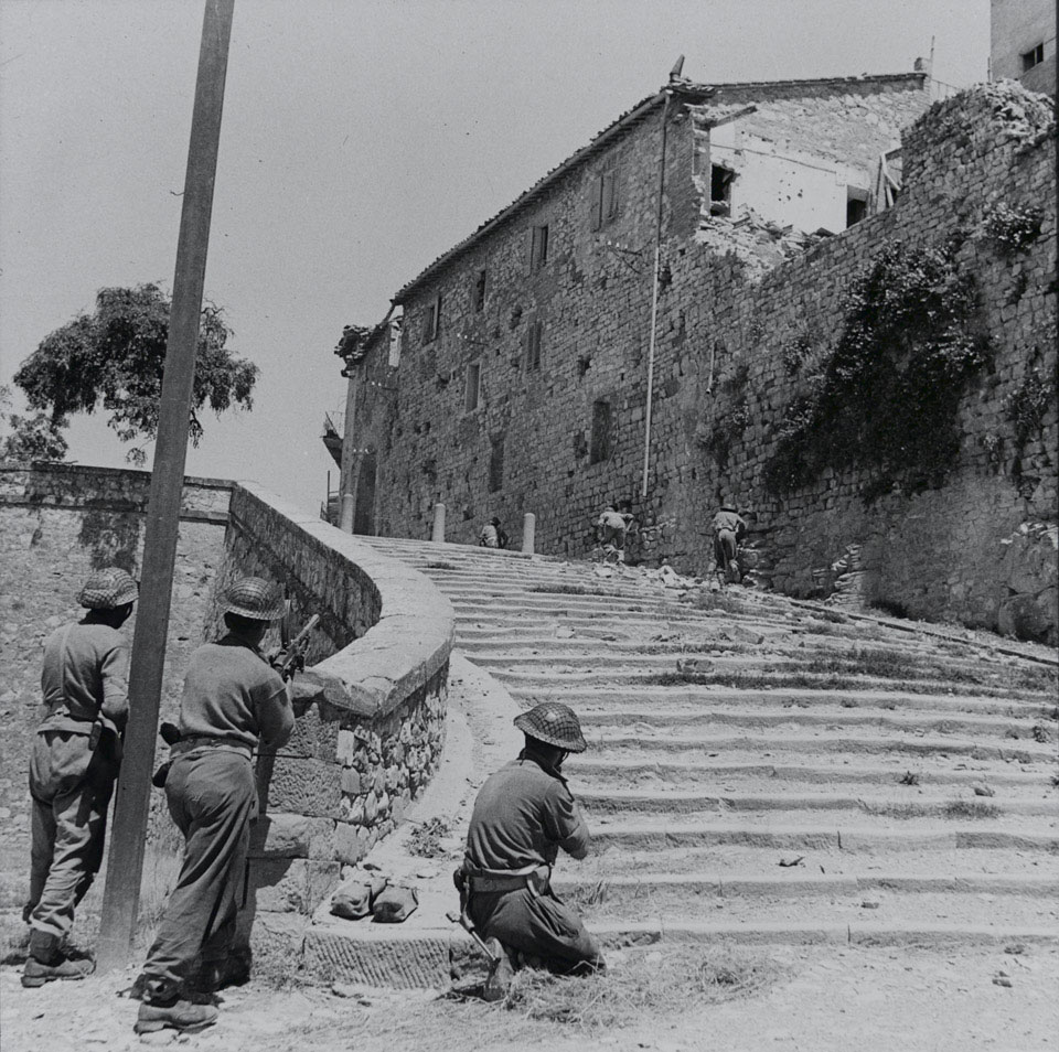 Infantry moving through the streets of Castiglione clearing any remaining German enclaves, June 1944