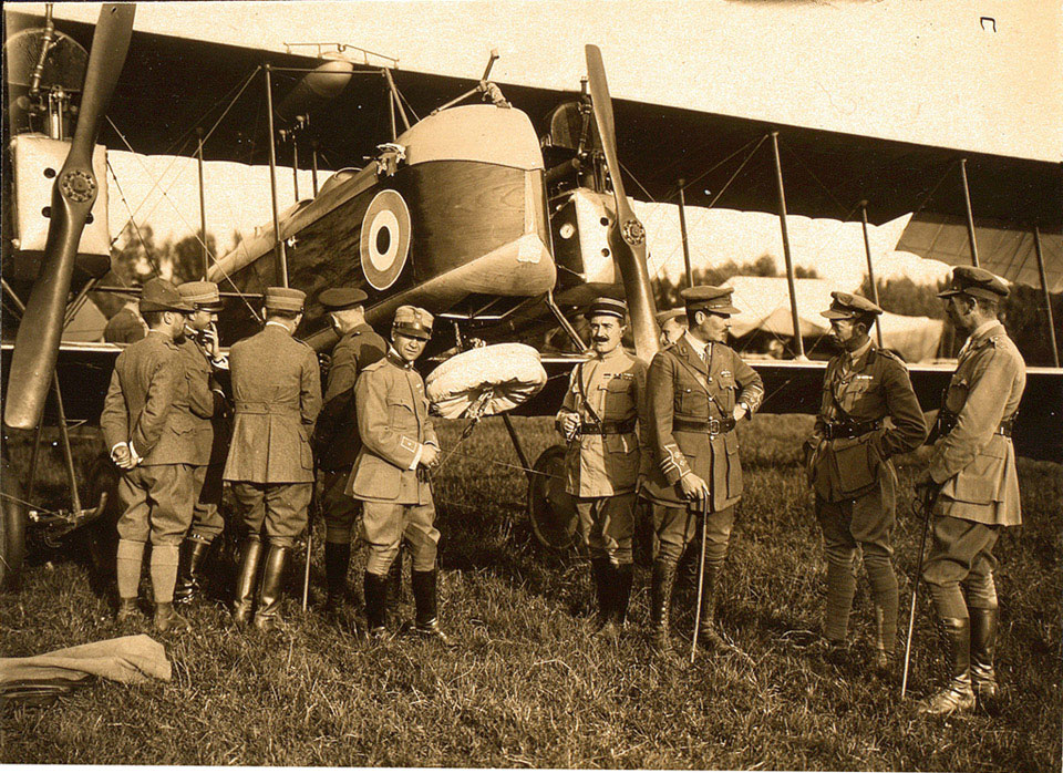 The parachute tied up under the forward observer's seat with British and Italian officers looking on, 26 June 1918