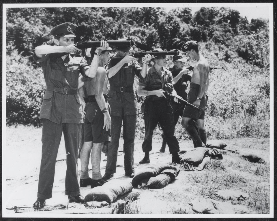 General Sir Gerald Templer (left) testing a .45 inch De Lisle bolt action silenced carbine during a visit to 1st Battalion The Gordon Highlanders, Perak, 1952