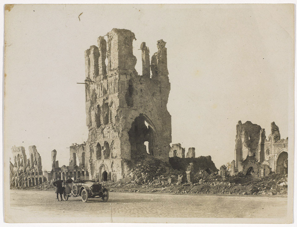 The ruined Cloth Hall at Ypres, with British soldiers in a motor car in the foreground, 1918