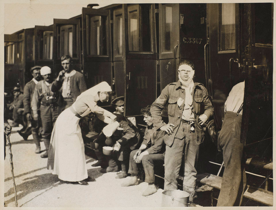 'Red Cross Sister serving tea to British soldiers who have been wounded and also injured by German gas', 1915 (c)