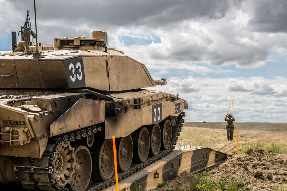 A Challenger 2 main battle tank crosses a bridge, guided by a Royal Engineer, Canada, 2015