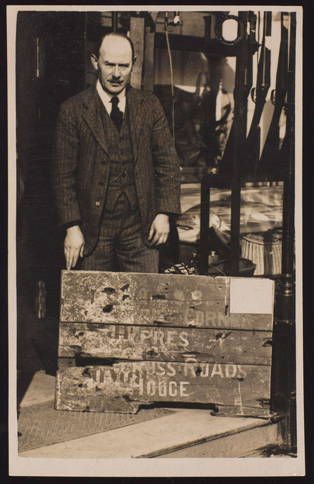 William Storie posing outside his shop with the signboard that marked 'Hellfire Corner', 1920 (c)