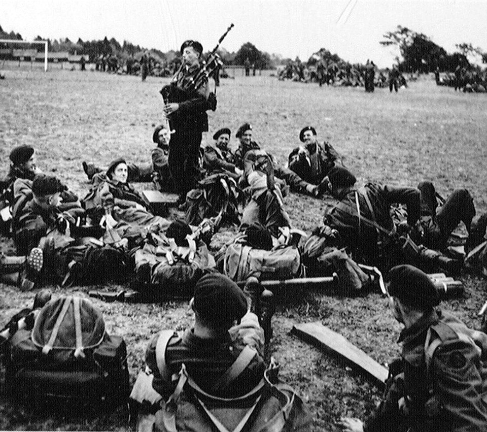 Personnel of 1st Special Service Brigade listening to Piper Bill Millin while resting, Normandy, 1944