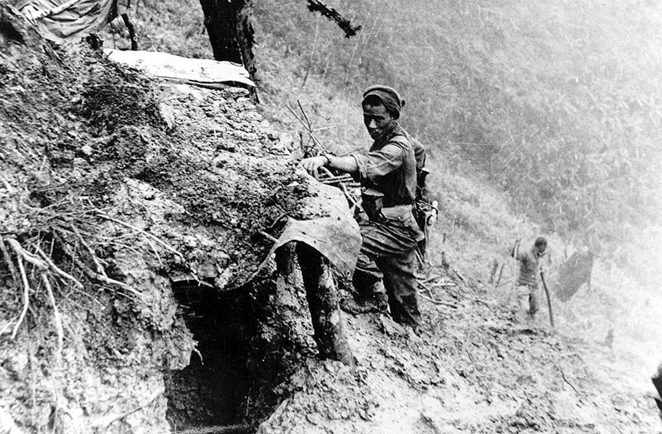 A Gurkha examines a Japanese bunker on 'Scraggy', Burma, April 1944