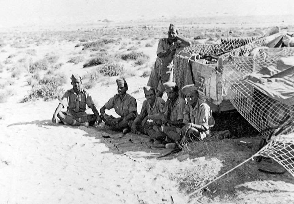 An Indian tank crew shelter in the shade of their vehicle, Western Desert, 1942 (c)