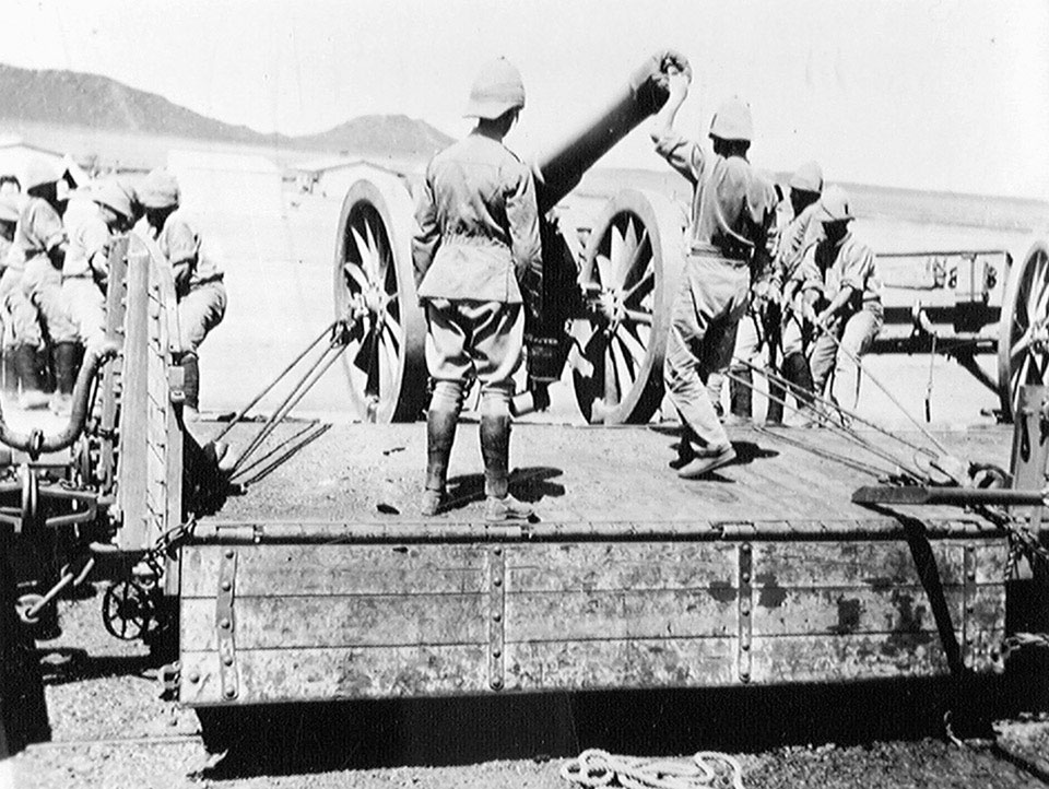 Soldiers of the Royal Artillery pulling a 5-inch gun on to a railway ...