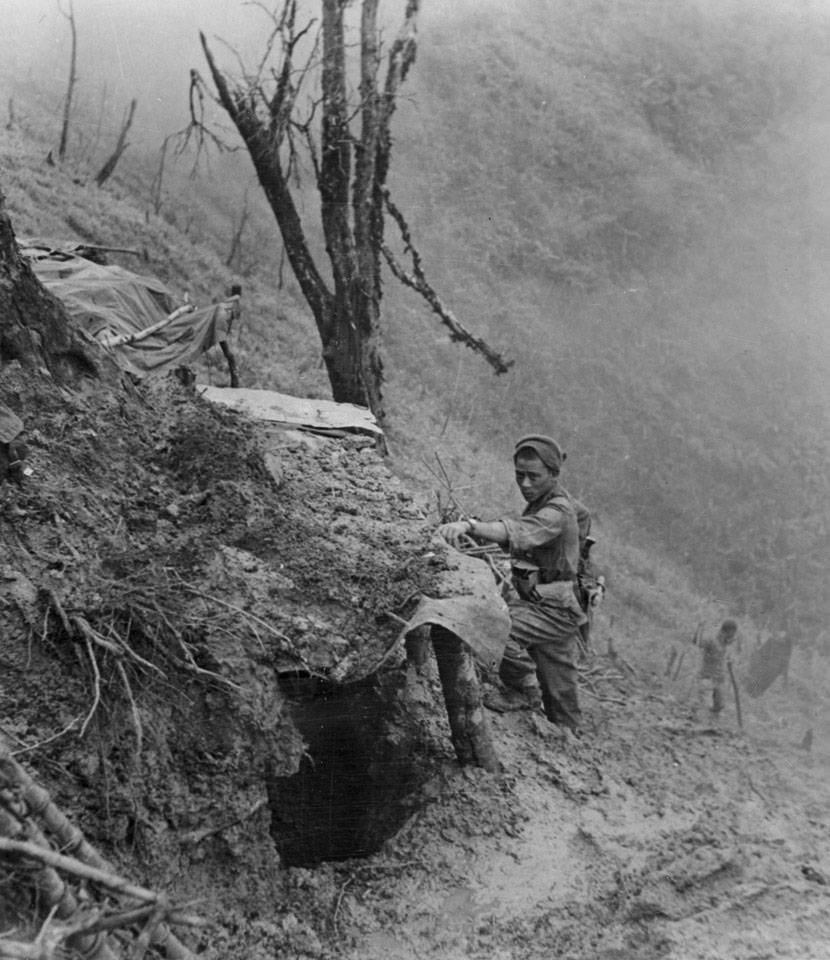 A Gurkha examines a Japanese bunker, 'Scraggy' hill, 1944