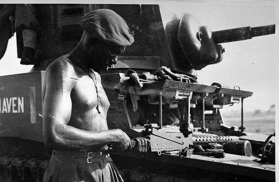 Soldier from the East African Reconnaissance Regiment, checking a machine-gun, Burma, 1945
